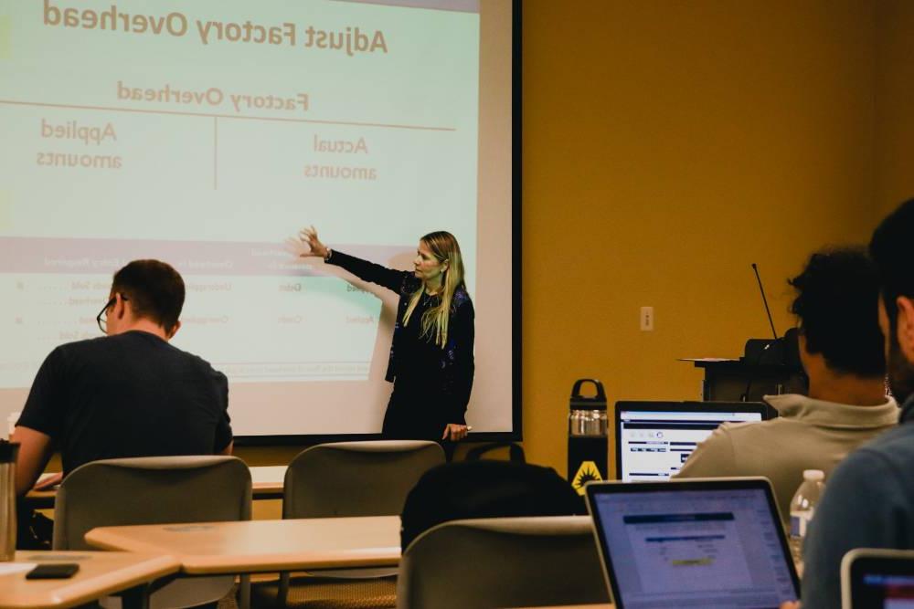 JU professor teaching using a projector.